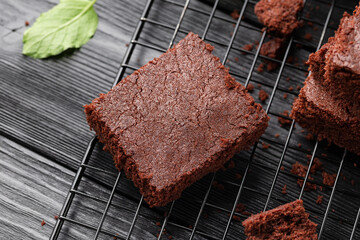 Chocolate brownies garnished with mint on cooling rack. Sweet food