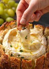 Baked Camembert cheese in sourdough bread with rosemary, garlic, thyme