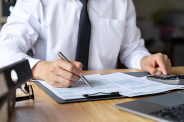 Banking and savings finance concept, close-up of businessman's hands filling out paperwork for tax refund and tax savings.