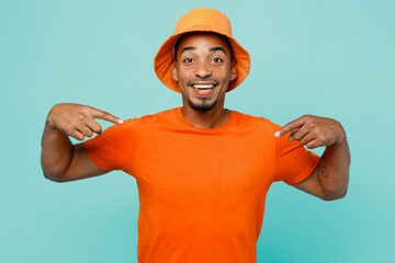 Young cheerful happy fun cool man of African American ethnicity 20s wear orange t-shirt hat point index fingers on himself isolated on plain pastel light blue cyan background People lifestyle concept