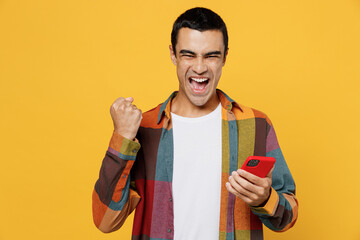 Young overjoyed happy fun middle eastern man 20s wear casual shirt white t-shirt hold in hand use...