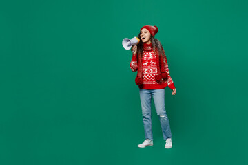Full body merry young woman wear red warm cozy knitted sweater hat posing hold scream in megaphone...