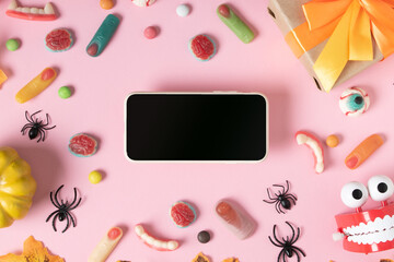 A smartphone with a black blank screen on a pink background with creepy marmalades.