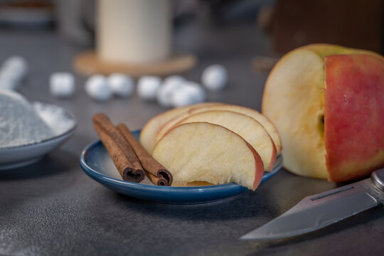 petite soucoupe avec des b&acirc;tons de cannelle et des tranches de pomme
