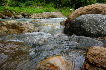 Naklejka na ściany i meble river with rocks in tropical indonesian nature 