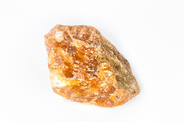Raw orange calcite stone macro isolated on white background