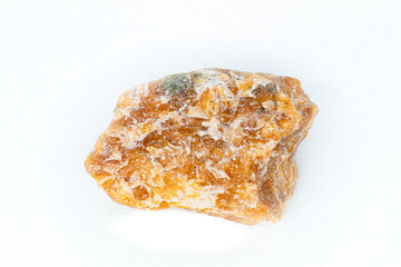 Raw orange calcite stone macro isolated on white background