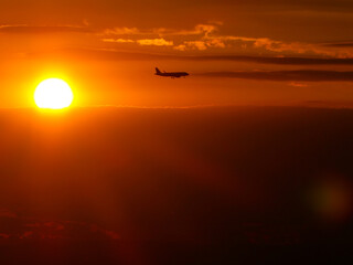 Avión descendiendo para aterrizar con fondo de atardecer rojo en Venecia