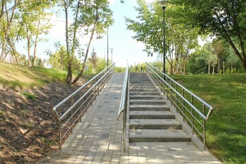 Stairs and ramp with metal railings for the passage of strollers and wheelchairs in public park....