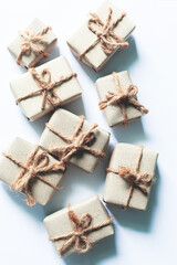 Brown gift box on a white background,A set of handmade gifts in kraft paper, tied with wide twine, decorated with dry flowers on a white table. Top view