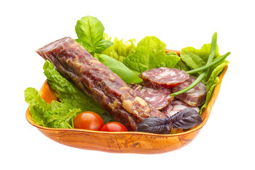 Ripe salami with salad, basil, onion and tomato