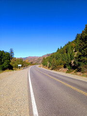 Fototapeta na wymiar Endless road with curve in mountainous landscape and blue sky. Driving and Landscape concept.