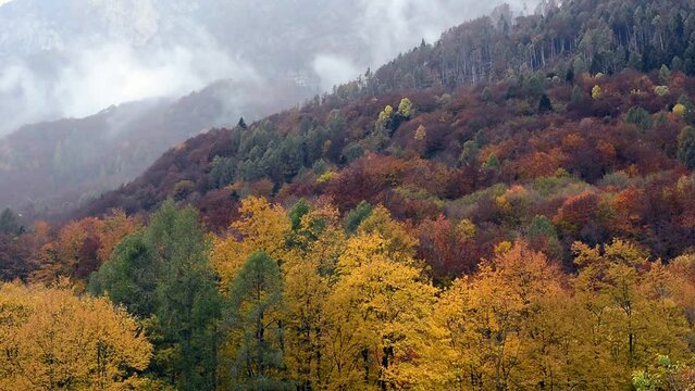 the wind moves the clouds over the autumn mountains