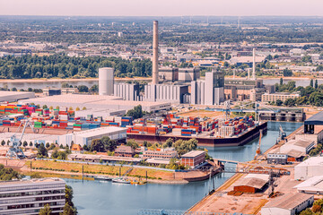An industrial port with cargo containers and factory pipes in the suburbs of Dusseldorf on the banks of the Rhine River