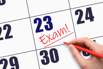 23rd day of the month. Hand writing text EXAM and drawing a line on calendar date.