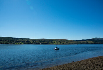 Landscape of Gare Loch with single sail boat