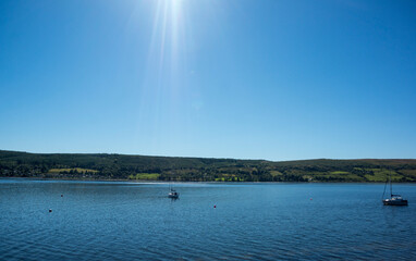 Landscape of Gare Loch with single sail boat