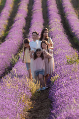 Portrait of a mother with her daughters on a background of lavender
