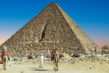 Bedouin men and tourists, in front of the Giza Necropolis pyramids complex. Egypt