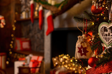 Advent calendar in the form of an eco bag hangs on the Christmas tree against the background of the Christmas room with a fireplace and Santa's boots.Christmas background. Advent calendar.