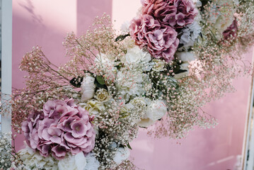 Arch for wedding ceremony a is decorated with flowers and greens, greenery. Wedding decor on backyard banquet area. Location for the wedding ceremony. Close up.