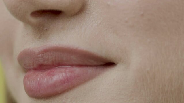 The lady who smiles modestly. Close-up, close-up smile. Clean skin and natural lips. Concept of customer satisfied with dental procedures