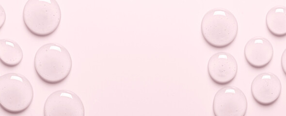 Pink drops of gel closeup. Cosmetic product for moisturizing the skin of the face or body. Copy space.