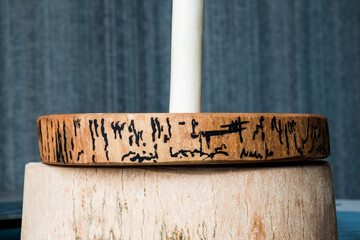 Ash wood paper towel holder. Beautiful texture. The pattern on the bark is encircled with acrylic paint and is similar in spelling to the Japanese characters "life" and "laughter" Close-up.