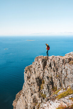 Travel in Norway woman on the edge cliff adventure active lifestyle vacations hiking outdoor aerial sea view top of mountain