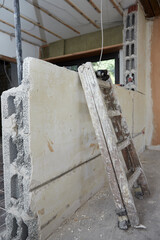 painter's ladder stands against a wall in a room of a construction site