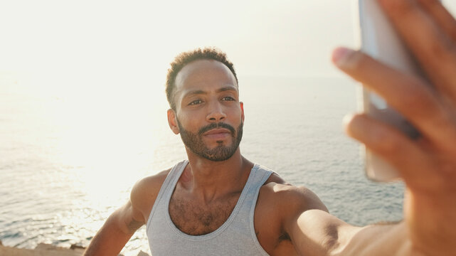 Close Up, Young Bearded Male Toned Athlete Uses Cell Phone While Resting After Training On The Embankment