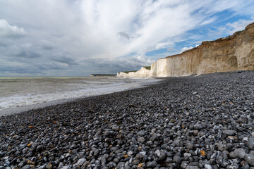 rocky beach at Birling Gap with the cliffs of the Seven Sisters in the background on the Jurassic Coast of East Sussex