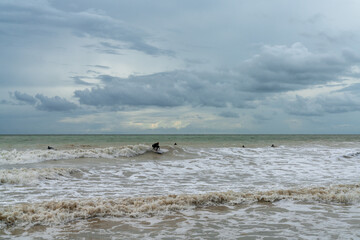 Fototapeta na wymiar surfer on a choppy wave in the stormy seas of the English Channel in East Sussex