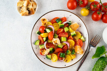 Vegetarian salad Panzanella with tomatoes, onion and bread Croutons. Light background. Top view. Italian salad