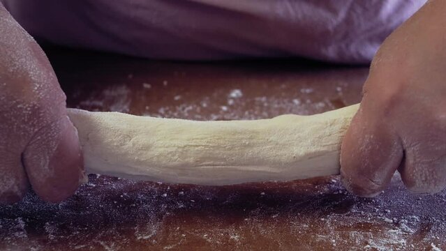 The hands of a Jewish woman knead the dough for baking festive challah