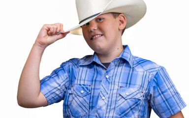 Handsome boy wears cowboy costume with blue plaid shirt and straw Texas hat, isolated on white....