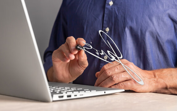 Digital signature concept. Signing e-document online via internet using laptop and stylus. High quality photo