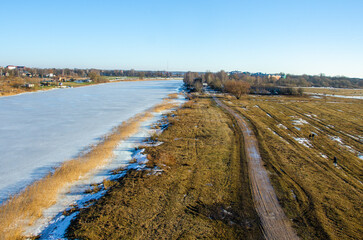 landscape with road near the frozen river in winter