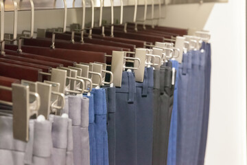 Group of navy pants on hanger at retail shop