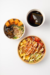 Several poke with fresh salmon, tuna, sauce on a white background