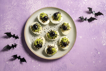 Deviled eggs with avocado. Spider for Halloween party