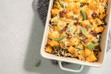 Autumn pumpkin casserole with leek, bacon, cheese and kale