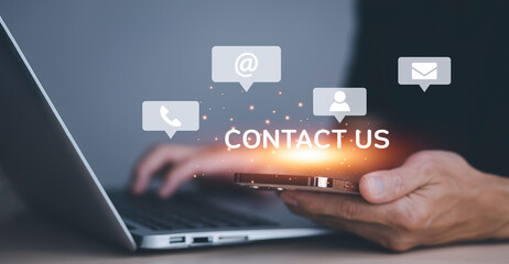 Communication and Contact us or Customer support hotline people connect. Hand using a laptop and touching on virtual screen contact icons, email and address, live chat with internet wifi.