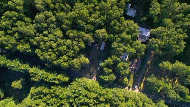 Imagen aerea cenital desde dron de un grupo de casas tipo caba&ntilde;a campestre, rodeadas de un gran bosque verde