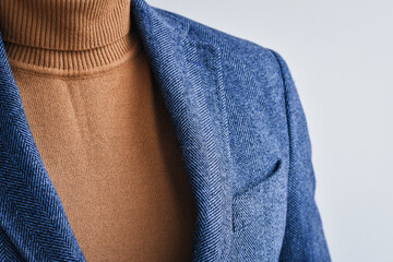 Fragment of classic tweed men's jacket with beige sweater. Fashion and lifestyle. Portrait of a buisinessman in a jacket. 