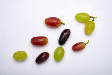 Various grapes are on the table. Isolated vines