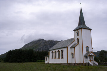 Fototapeta na wymiar Valberg, Norway - July 18, 2022: Valberg Church is a parish church of the Church of Norway in Vestvagoy Municipality in Nordland county. Cloudy summer day. Selective focus