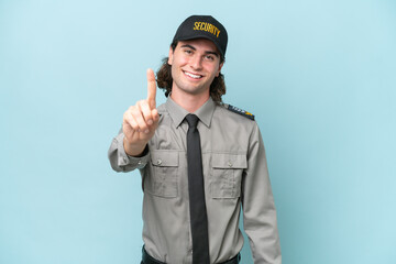 Young safeguard man isolated on blue background showing and lifting a finger