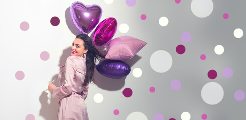 Valentine Beauty girl with colorful heart air balloons laughing, isolated on white background. Beautiful Happy Young woman. Holiday birthday party,  having fun, celebrating with pink color balloon