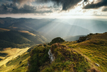 Amazing landscape in the mountains at morning. View of sun rays over hills and valleys. Beam of light from clouds on the mountains. The Maramures Natural Park. Carpathians. Romania. Europe.